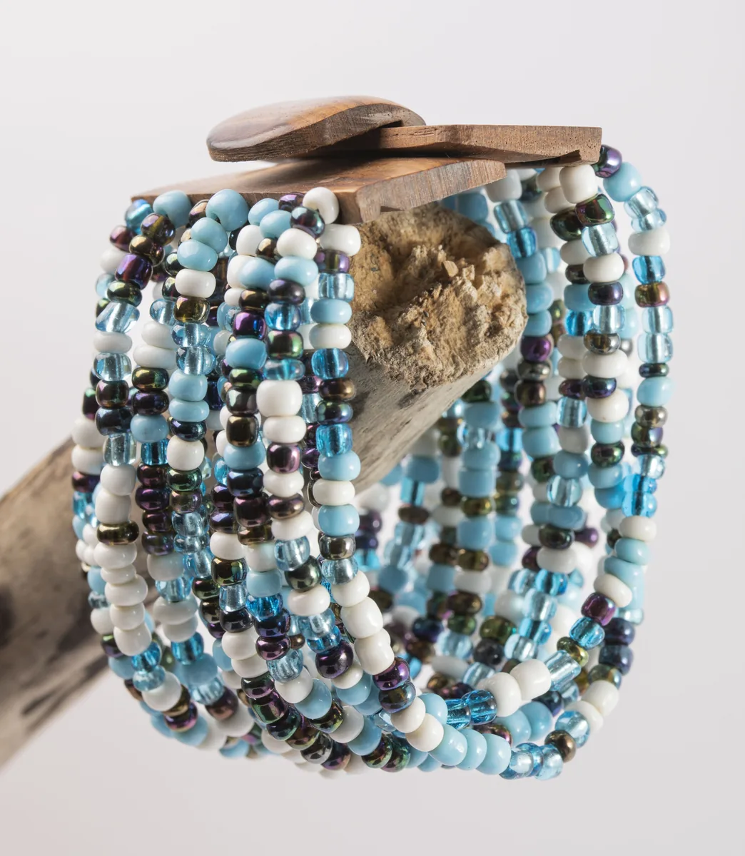 Bracelet manchette en perles de rocaille bleues et blanches sur bois