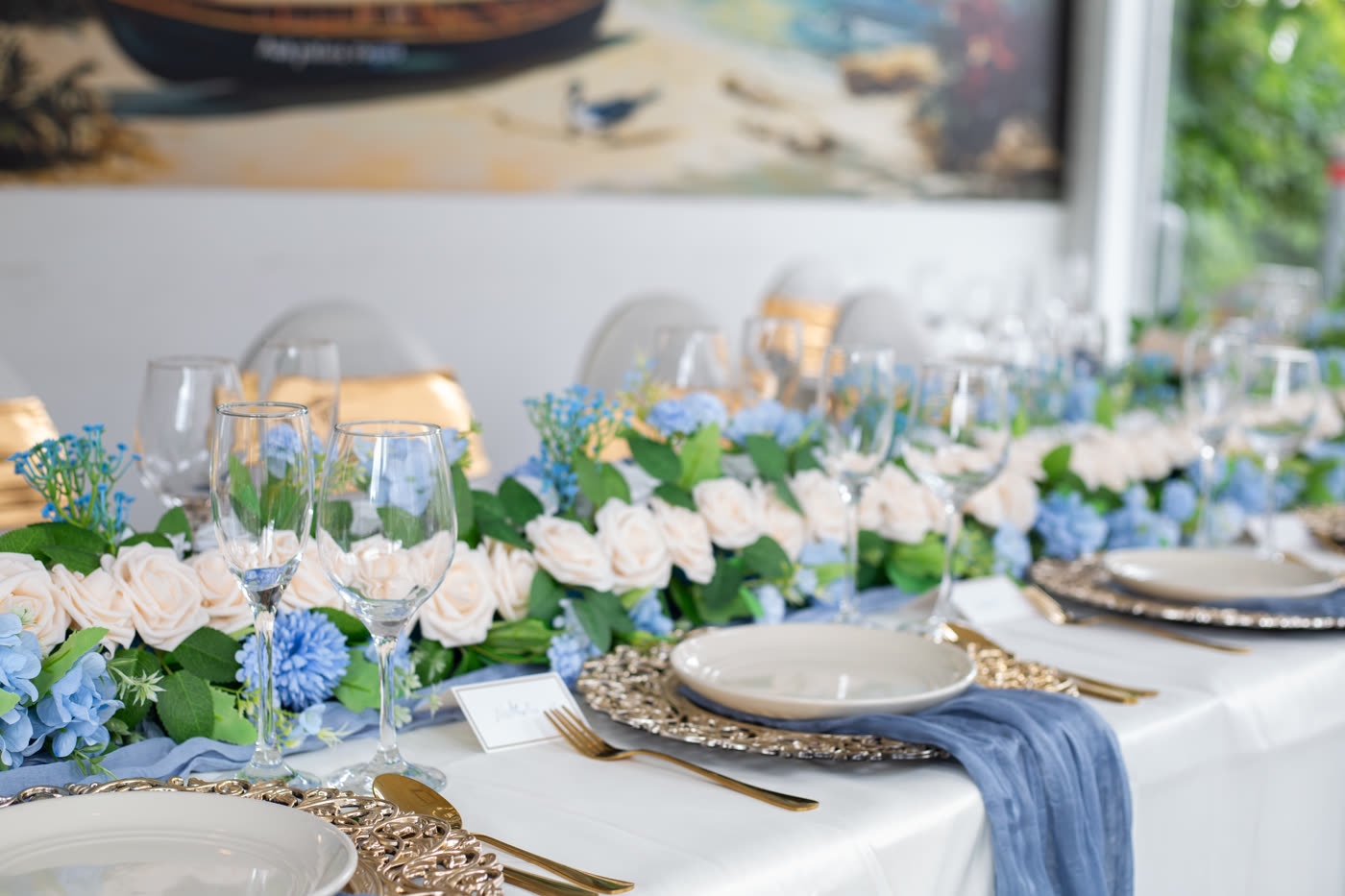 Détail de centre de table avec roses blanches et fleurs bleues