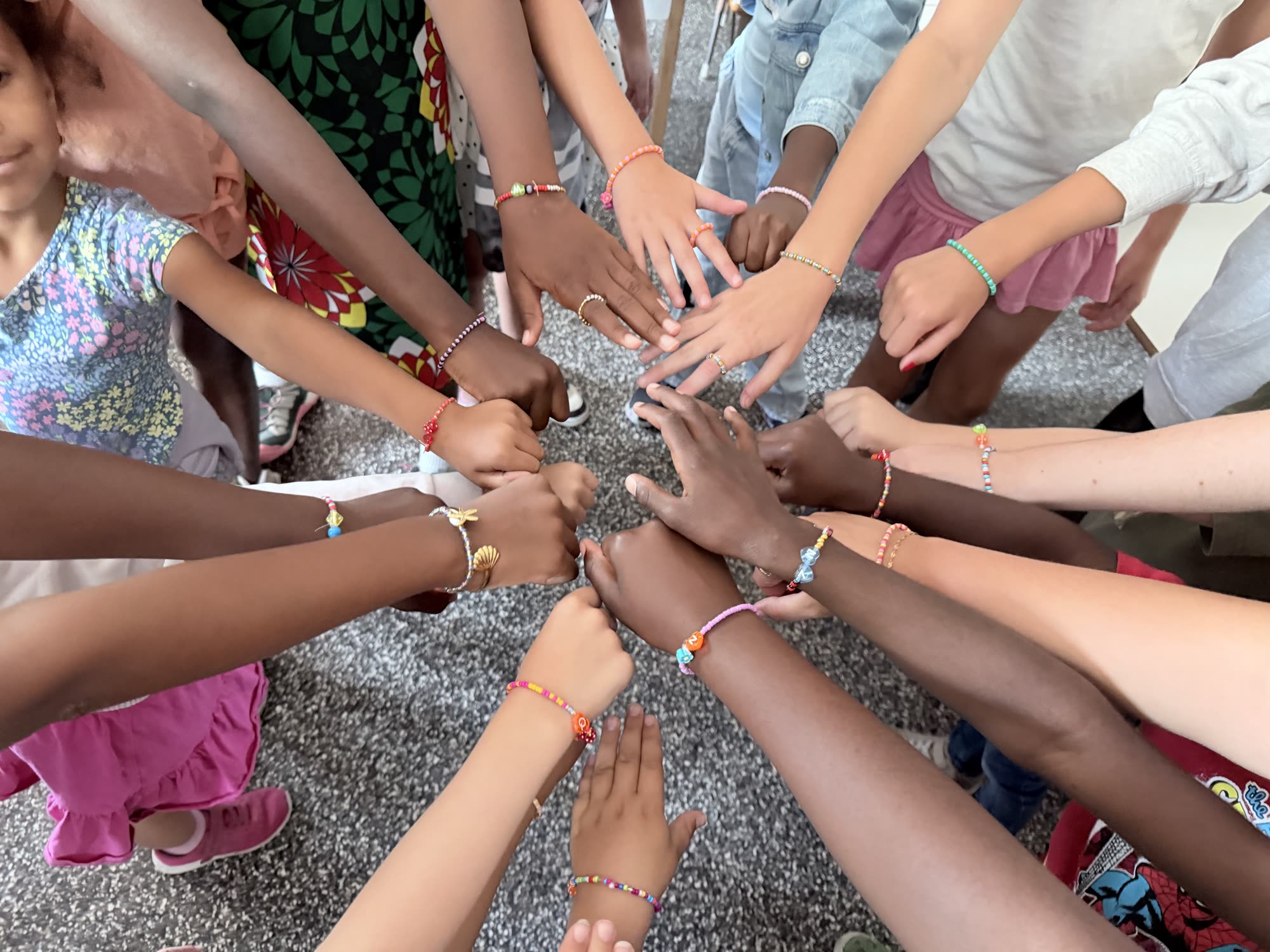 Groupe d'ados montrant leurs bracelets de perles faits en atelier