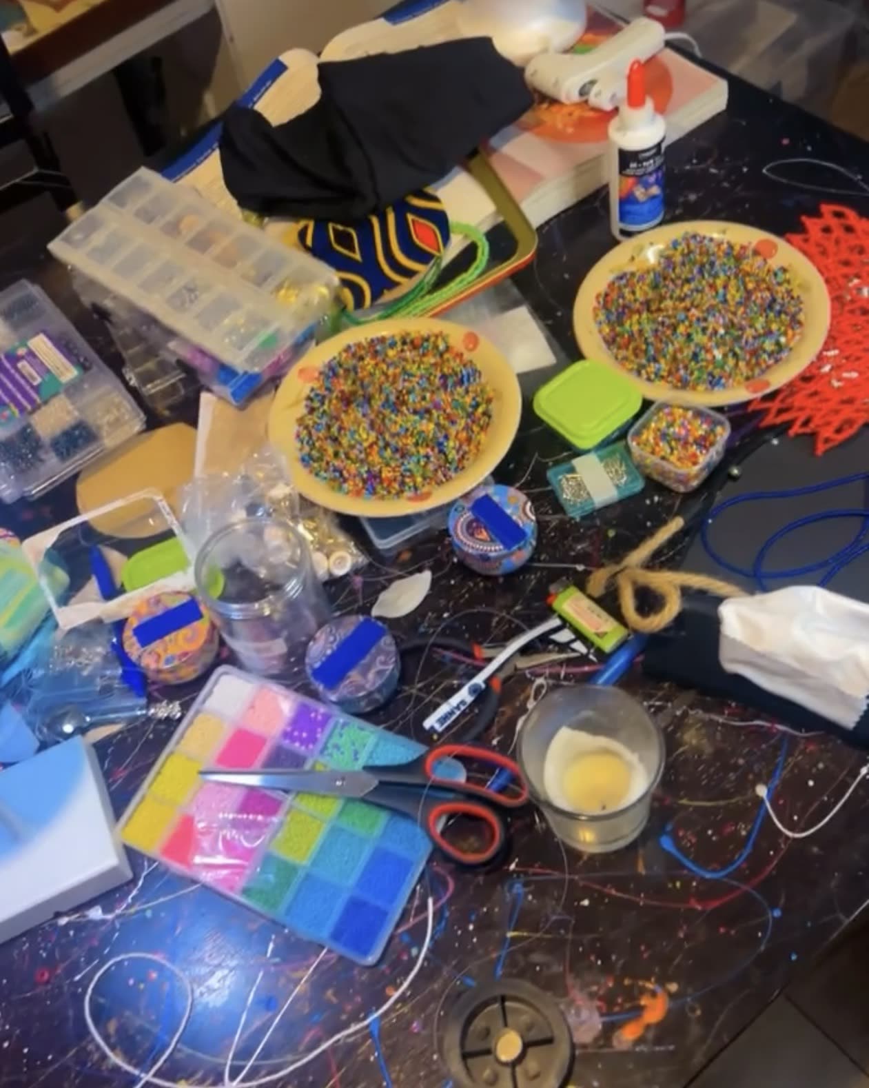 Table de travail avec bols de perles multicolores et matériel de création de bijoux
